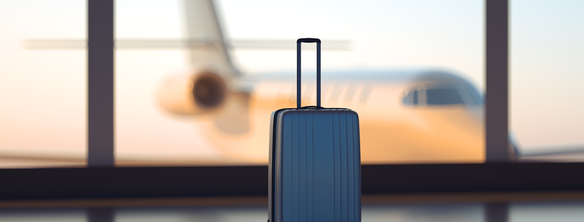 suitcase in an airport with a plane in the background