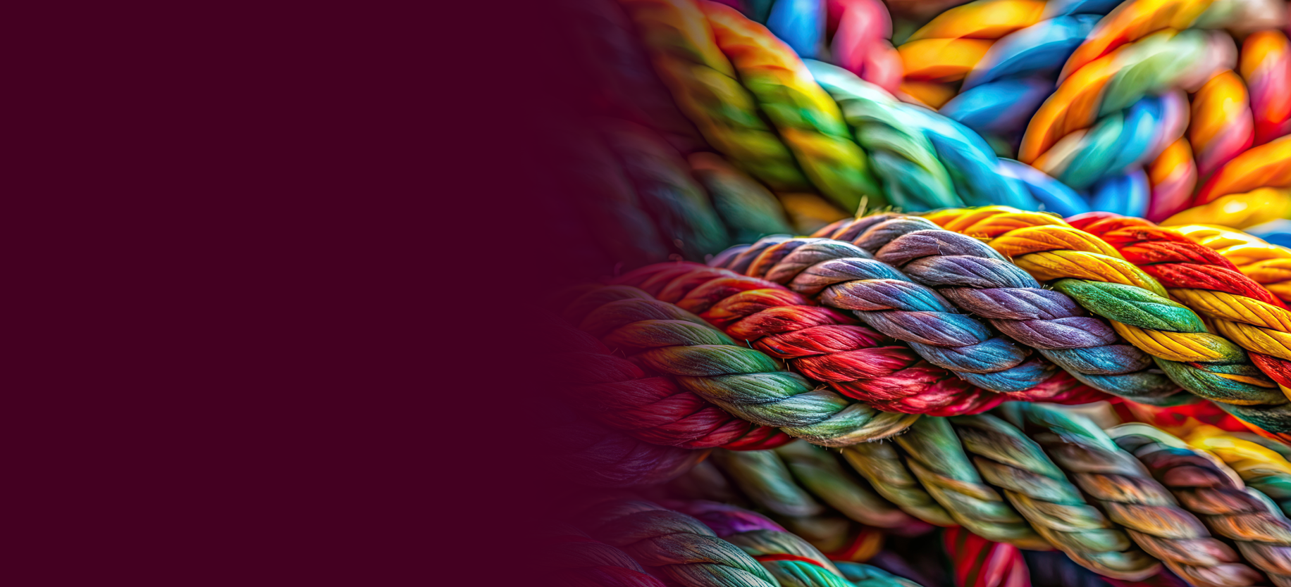 Close-up of colorful intertwined ropes with rich textures and intricate twists against a blurred background