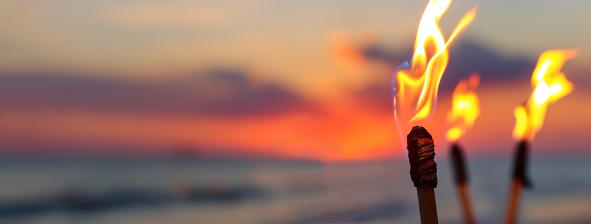 Tiki torch on a beach at sunrise